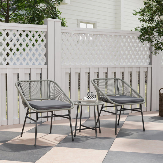 The rattan furniture set placed on a patio with a white fence and greenery in the background