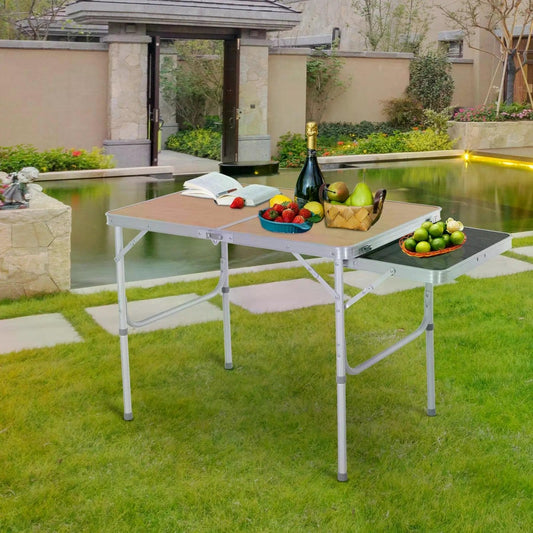The camping table set up outdoors with food and drinks on it