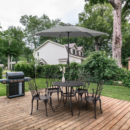 A cast aluminium garden dining set for four with a round table and four chairs on a wooden deck with a parasol and barbecue