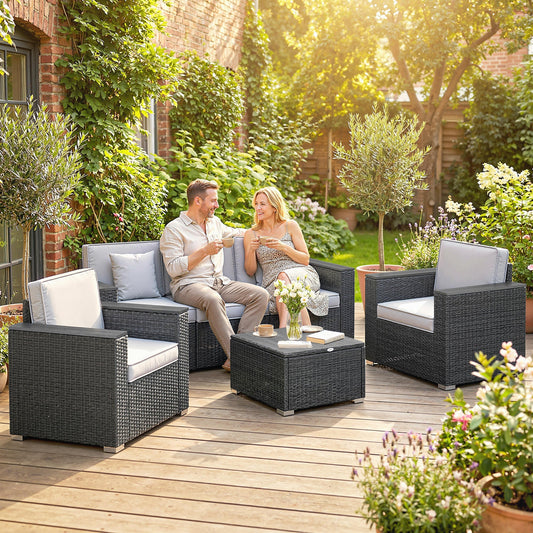 A couple relaxing on the dark grey rattan garden furniture set on a wooden patio