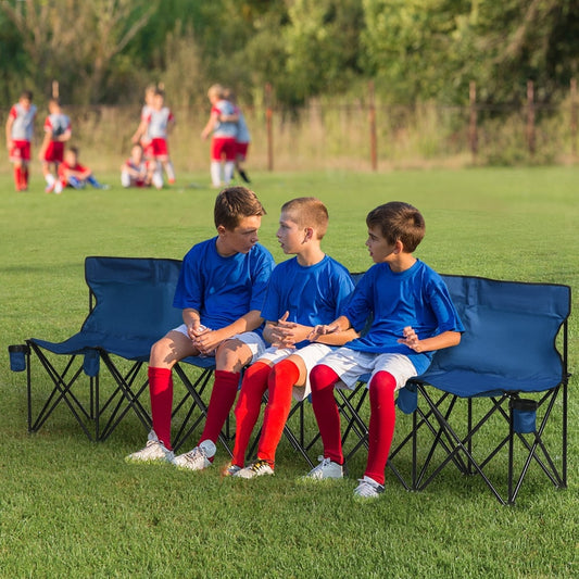 Three boys sitting on the blue six seater folding camping chair on grass