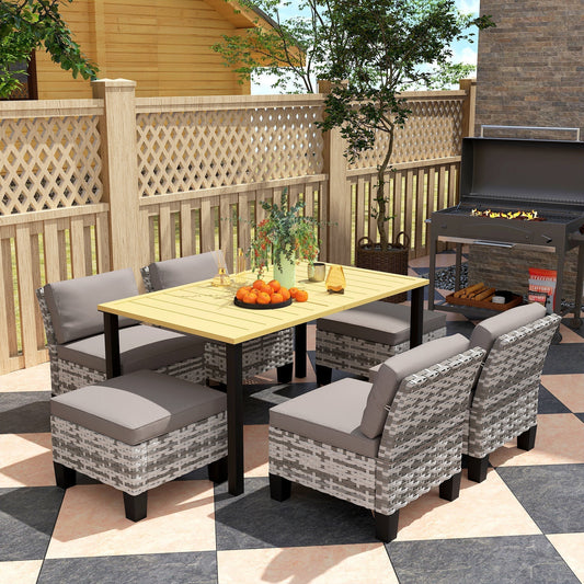 Rattan dining set arranged on a patio with a barbecue in the background