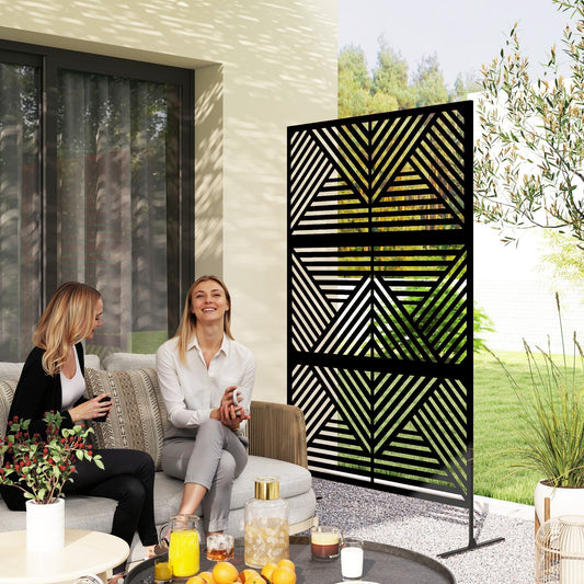 Two women sitting on a sofa on a patio next to the decorative garden privacy screen