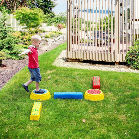 A young boy balancing on a yellow stepping stone as part of the kids balance bridge set in a garden