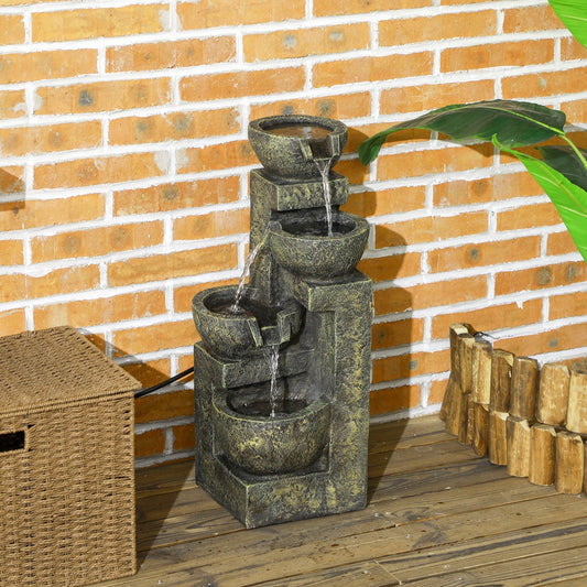 The garden fountain with four stone-look bowls sits on a wooden deck next to a basket