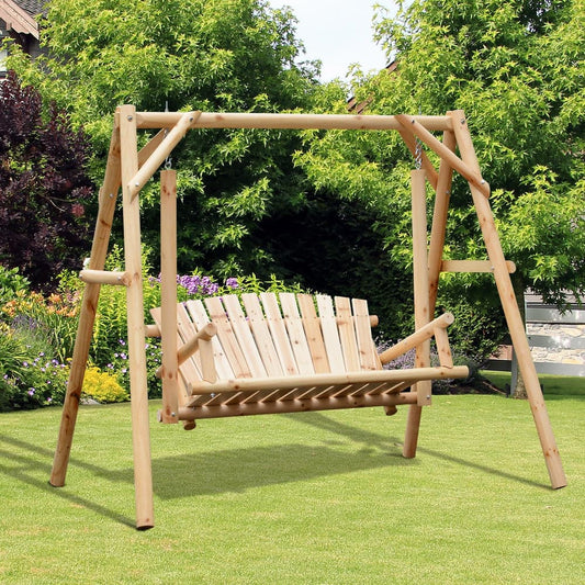 The wooden garden swing seat is set up on a lawn with green plants and flowers behind it