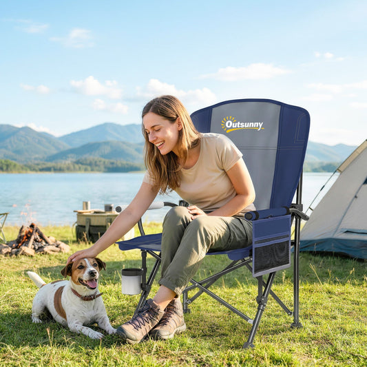 The camping chair is set up outdoors by a lake with a woman and dog sitting in it