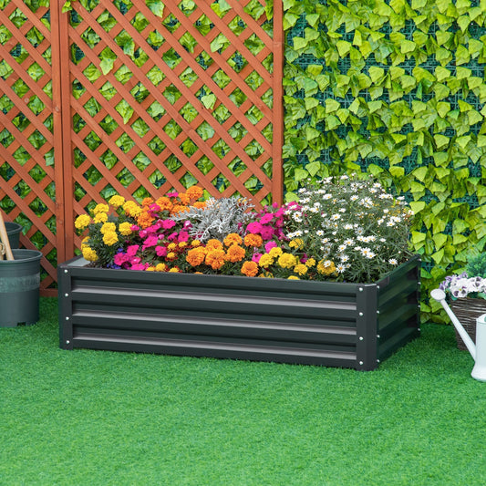 The galvanised raised garden bed placed on green grass in a garden setting