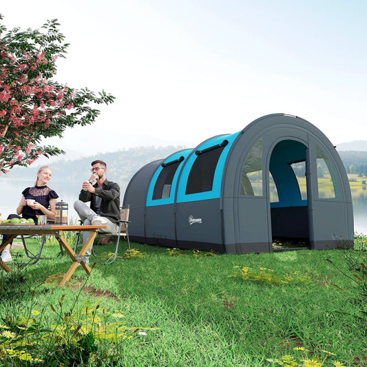 A couple relaxing outside a grey and blue six man duo room tunnel tent pitched on grass by a lake