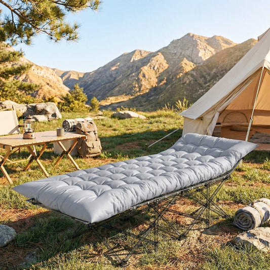 The camping mattress pad is set up on a camping bed outdoors next to a tent