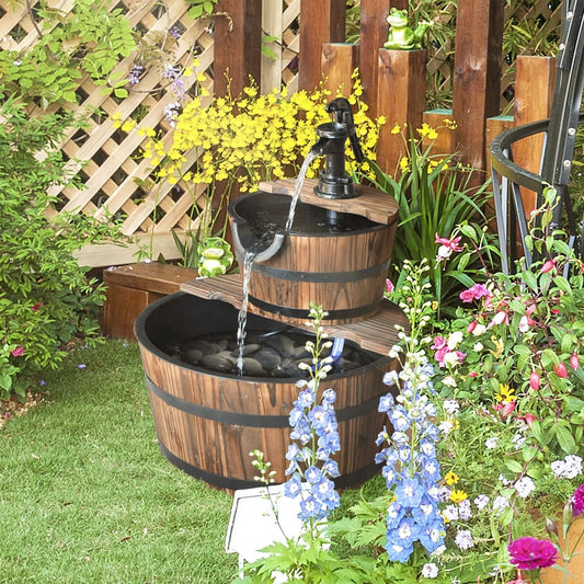 The garden fountain in use, with water flowing down the tiers surrounded by flowers and greenery