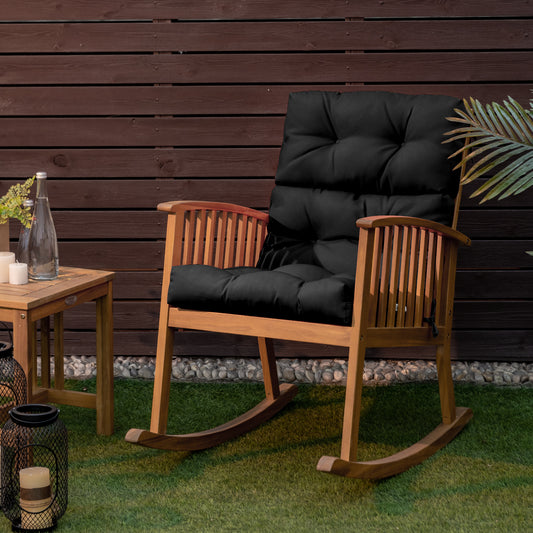 The black outdoor furniture cushion on a wooden rocking chair on a patio