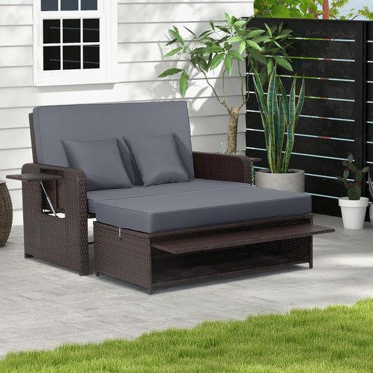 The grey patio furniture set is shown set up as a daybed on a wooden deck next to a white wall