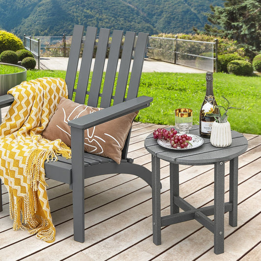 The grey patio side table next to a grey garden chair with a yellow blanket and a drink on top