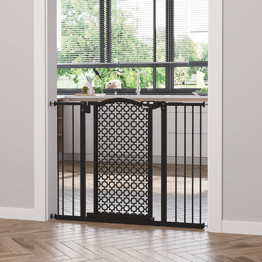 The black metal dog gate installed in a doorway between a kitchen and a living area