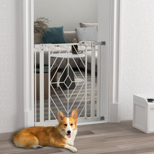 The white metal dog gate is installed in a doorway, with a corgi lying down in front of it