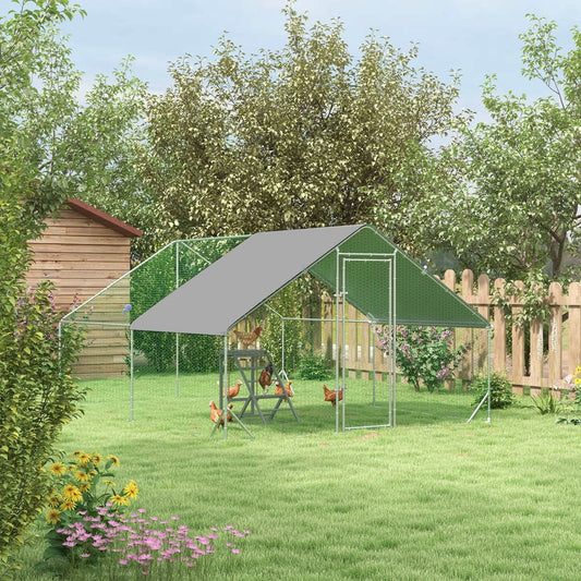 The chicken run set up in a lush green garden with several chickens inside the enclosure
