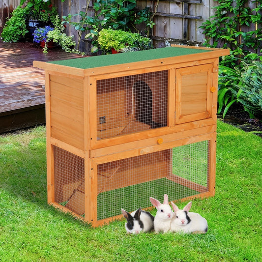 The guinea pigs hutches placed on a green lawn with three small rabbits sitting in front