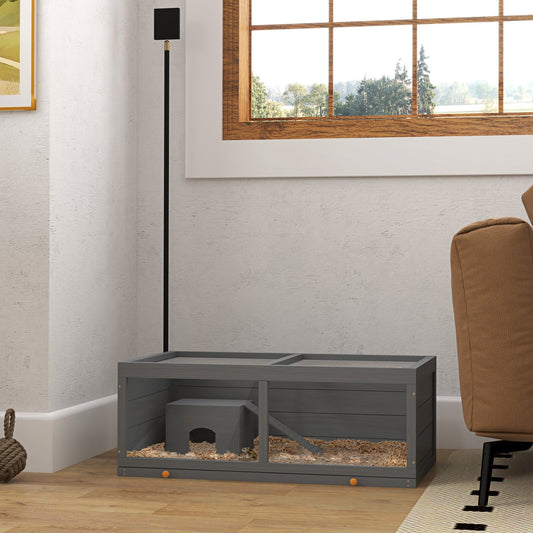 The hamster cage placed on a wooden floor in a living room setting