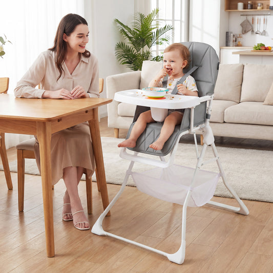 A woman and a baby sit at a dining table with the grey high chair