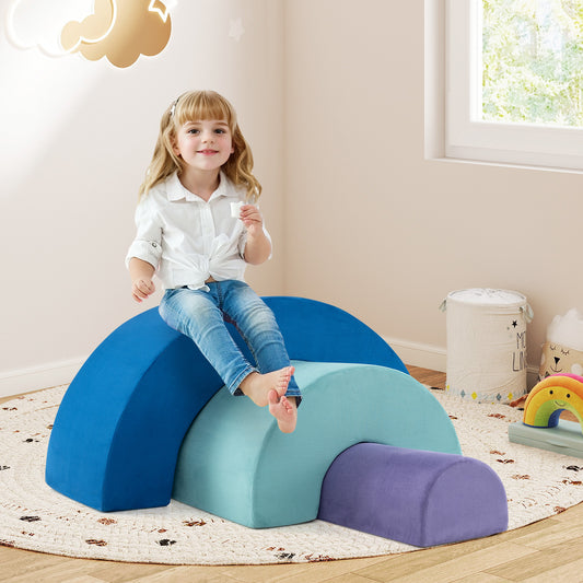 The foam climbing blocks arranged as a nested arch set with a young girl sitting on top