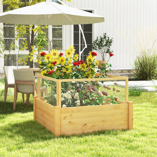 The wooden garden bed with a wire fence and grid filled with blooming flowers on a lawn