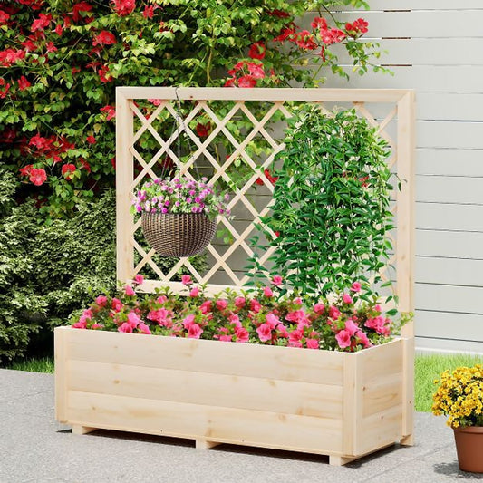 The wooden planter placed on a patio with a hanging basket and climbing plants in the trellis