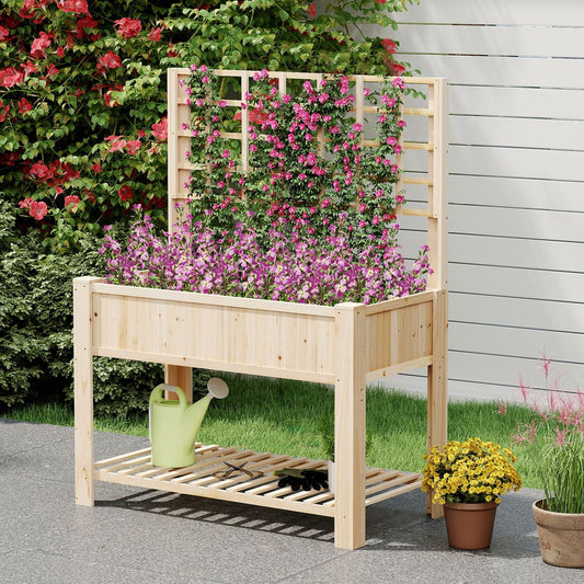 The wooden planter box placed on a patio with pink flowers growing up the trellis