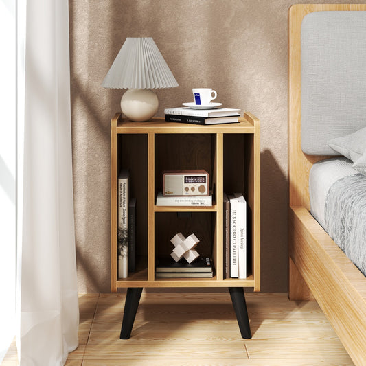 The end table is shown in a bedroom next to a bed with a lamp and books on the shelves