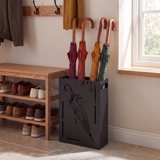 The black umbrella stand is in a hallway next to a shoe rack and a wooden bench