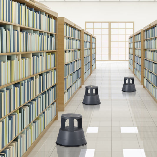 The rolling ladder stool placed in the aisle of a large library with many bookshelves