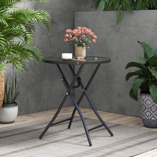 The patio table set up on a balcony with plants and a grey wall