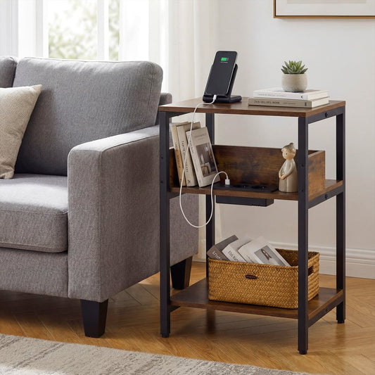 The three-tier end table next to a grey sofa, with a phone charging on top