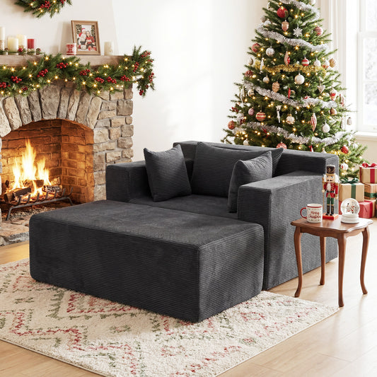 The grey foam sofa placed in a cosy living room next to a lit fireplace and Christmas tree