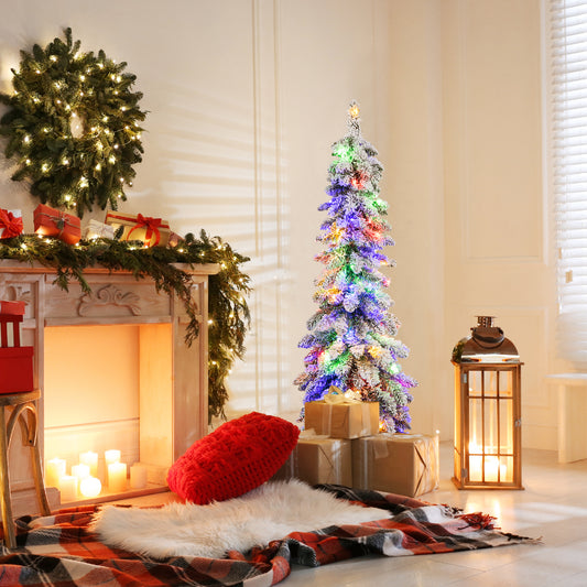 The slim pencil Christmas tree is lit with colourful lights and placed in a cosy room next to a fireplace