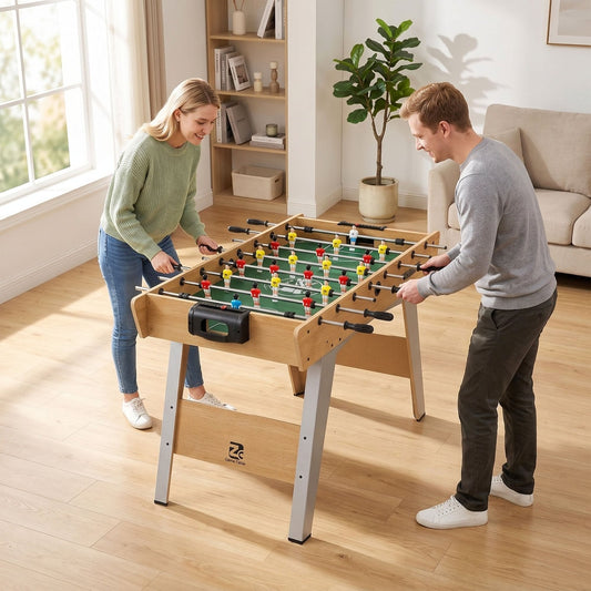 A couple playing a game of table football in a living room