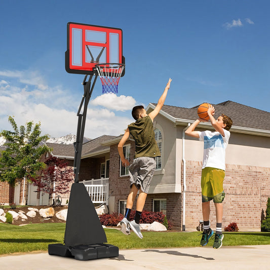 The basketball hoop set standing on a driveway with two boys playing a game of basketball