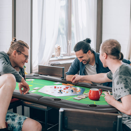 A group of four men playing a board game on the green poker table top in a living room setting