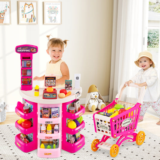 Two young children playing with the pink grocery store set in a bright living room