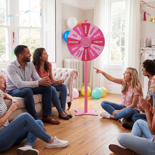 The prize wheel being used by a group of friends at a party with colourful balloons