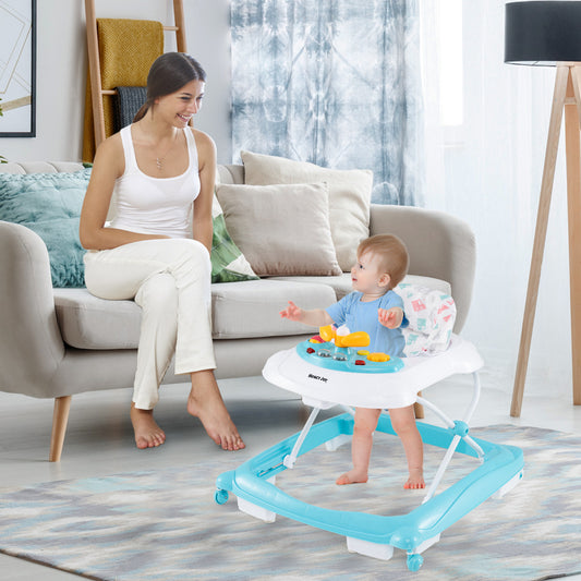 A mother watches her baby in the green baby walker in a living room