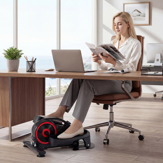 A woman using the under desk elliptical pedal exerciser while working at her desk