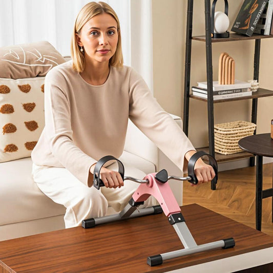 The exercise bike being used for an arm workout by a woman sitting on a sofa