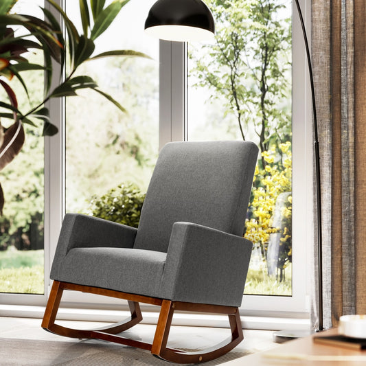 The grey rocking chair with a wooden base positioned in a sunlit room by a window