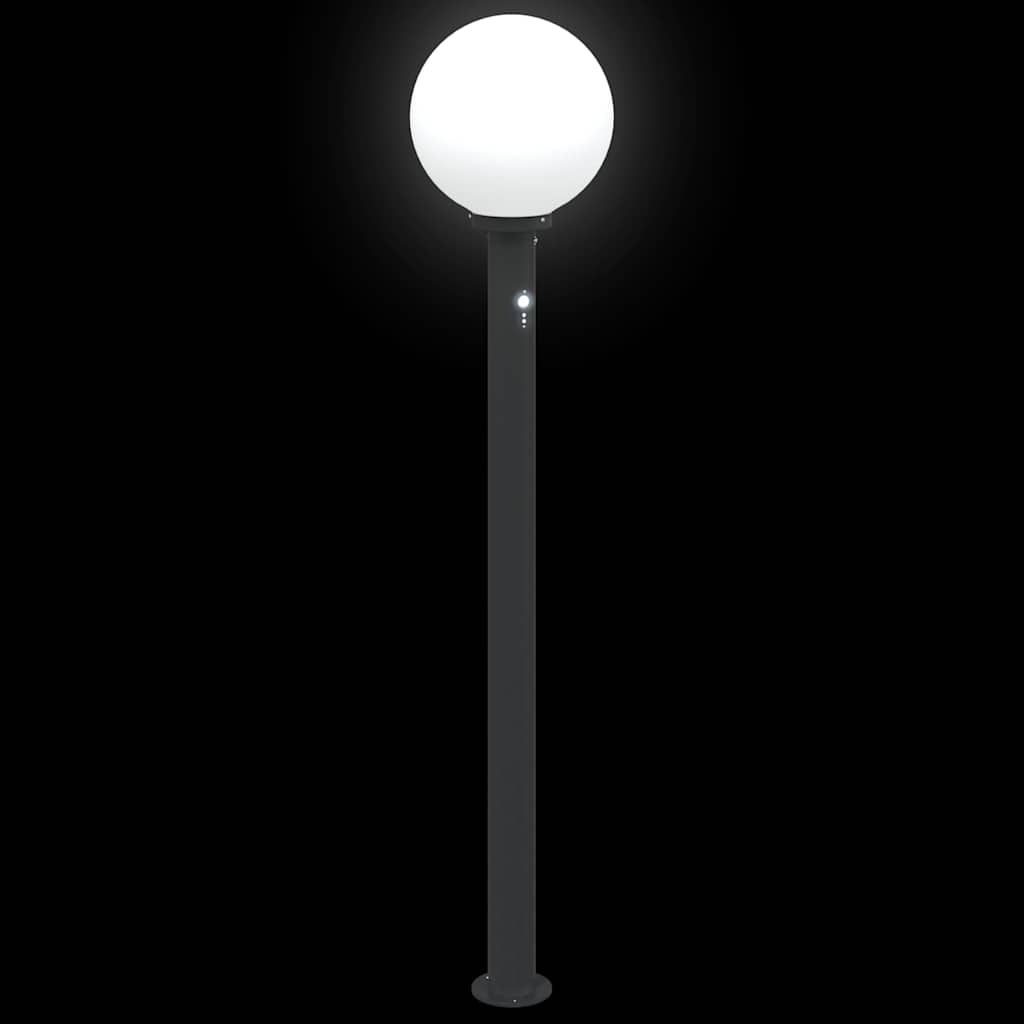 A black bollard lamp with a white globe light illuminated at night