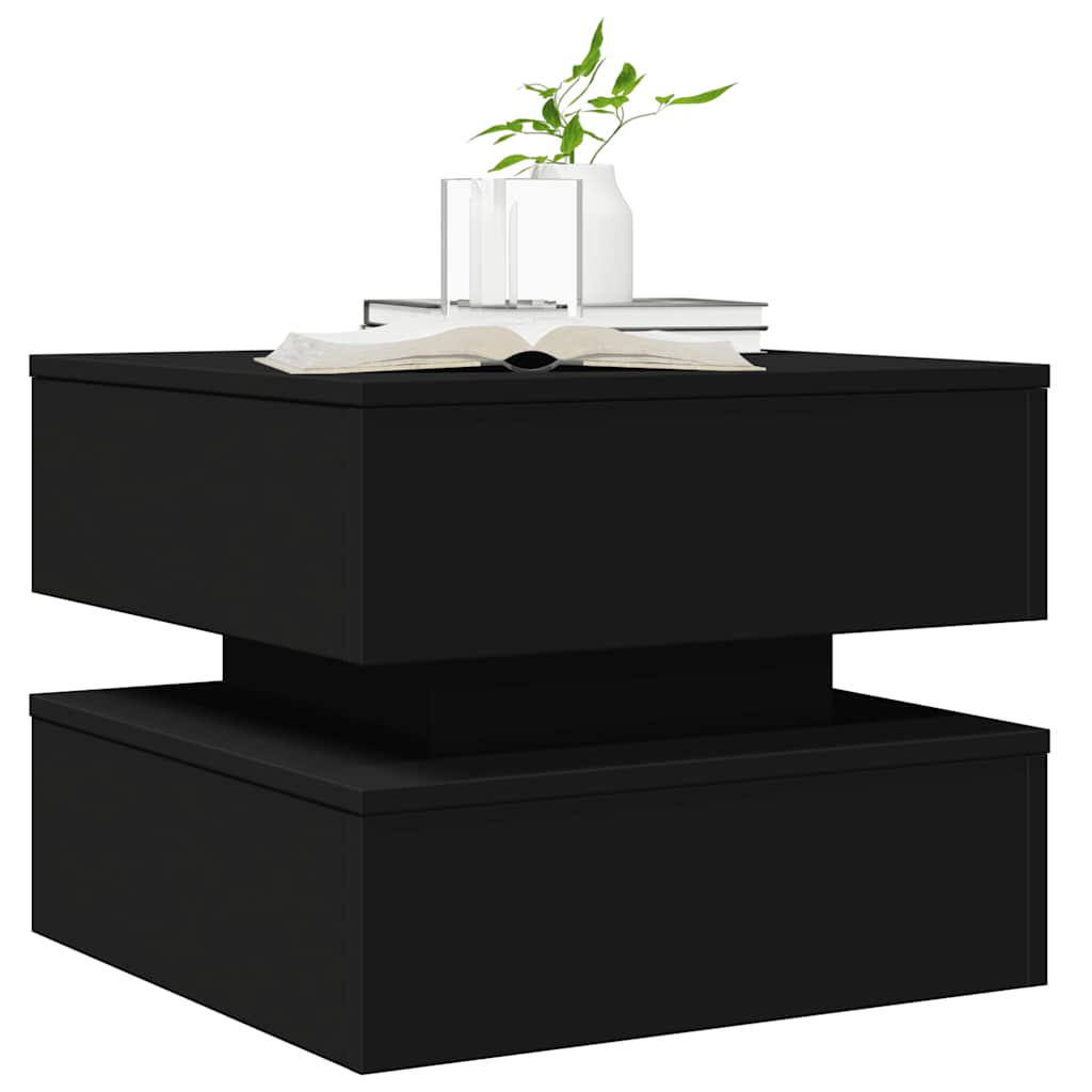 Close-up of the black coffee table with a book and vase on top