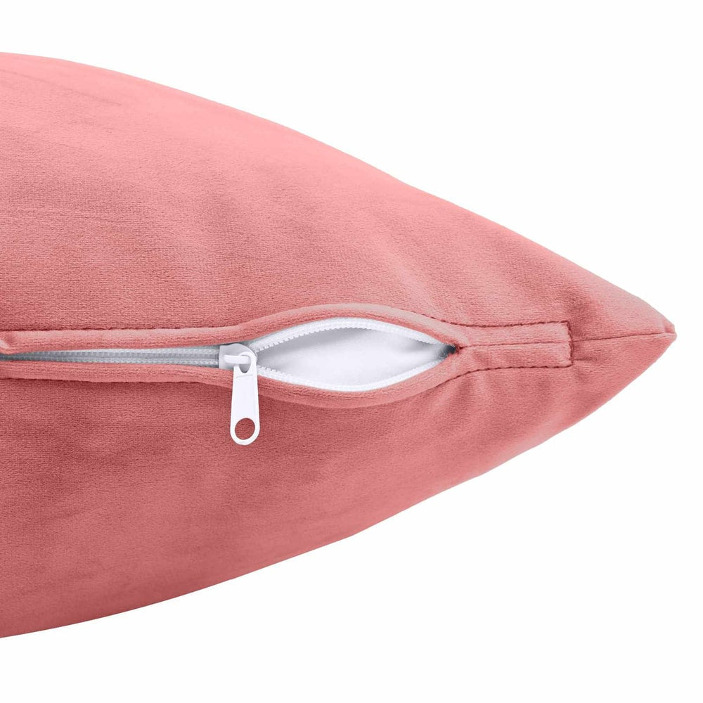 Close-up of the side of a pink velvet cushion showing the zip