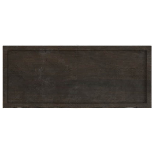 The dark brown treated solid wood oak table top, showing its full length and width