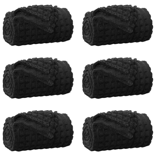 Six rolled up black fleece blankets arranged in two rows
