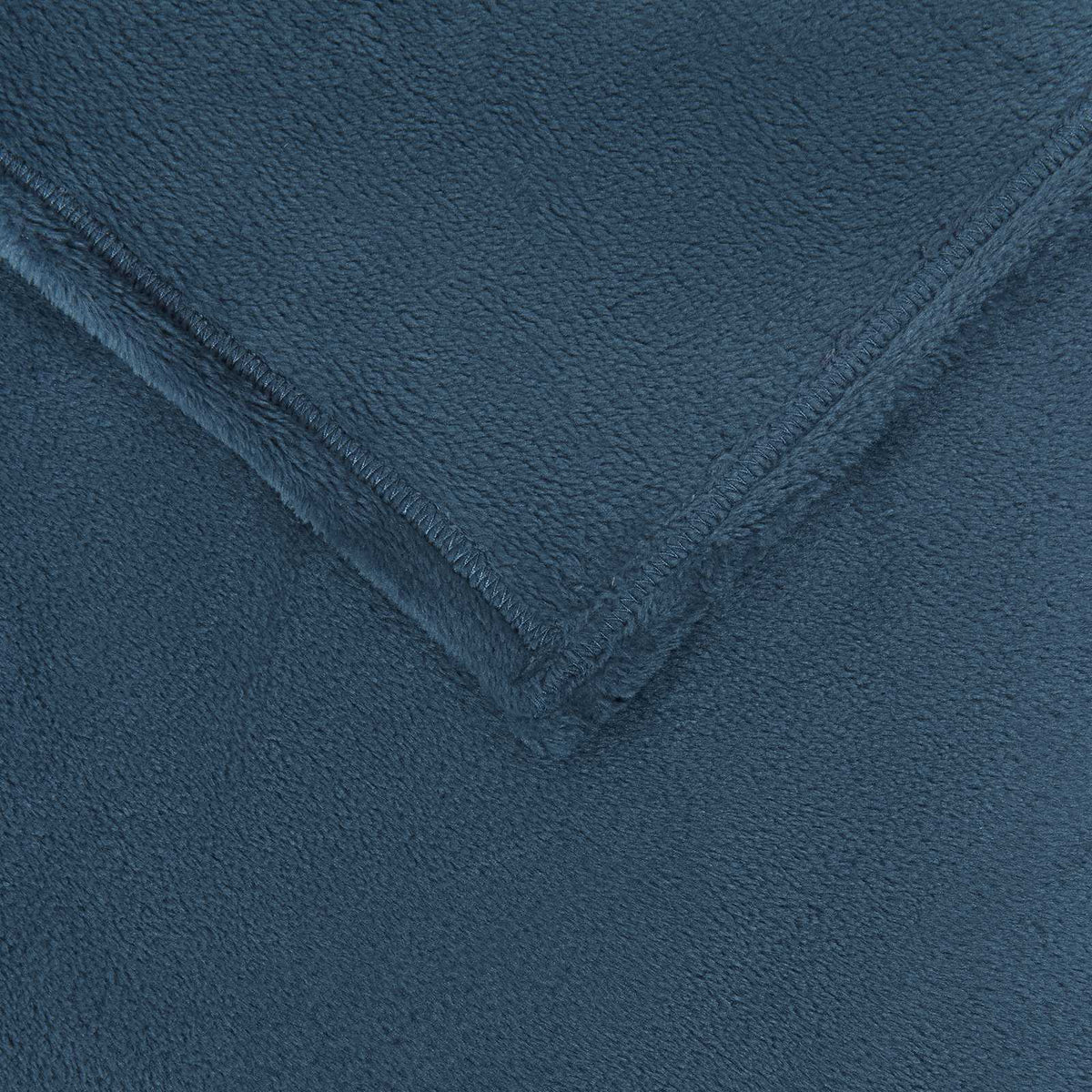 Close-up view of the soft texture and navy blue colour of a fleece blanket
